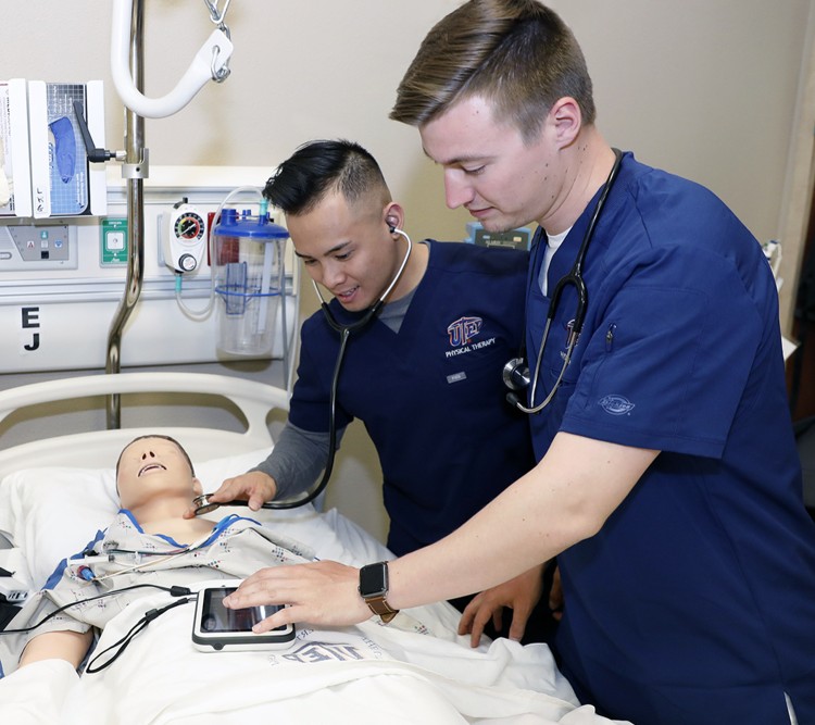 Two nusring students working with a mannequin