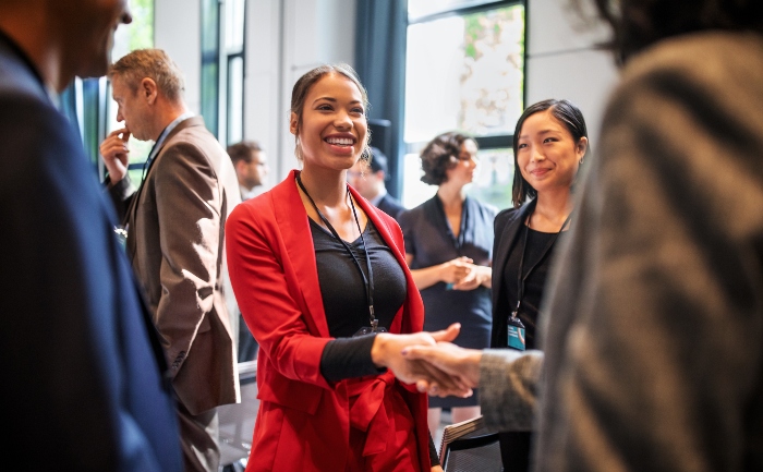 Young communications professional handshaking during a conference gathering | UTEP Connect Online Degrees 