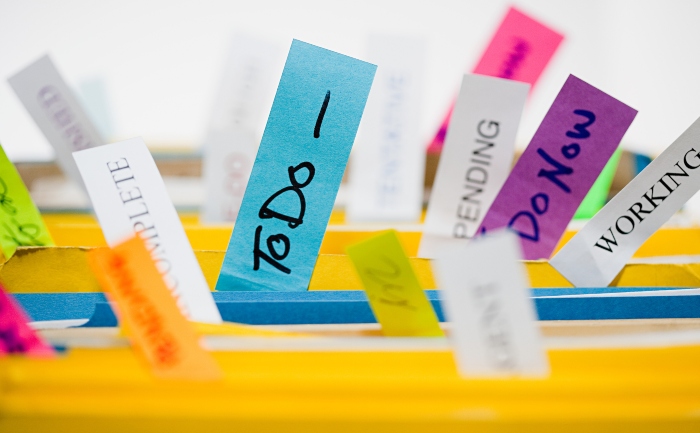 File folders with colorful labels signifying progress on a to-do list like do now, pending, working, and more.