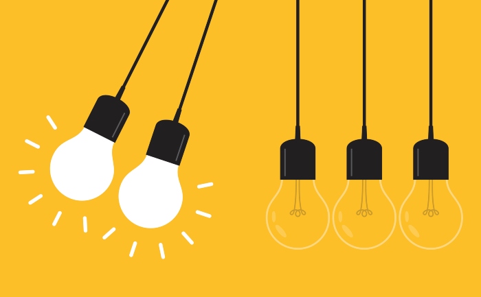 Newton’s cradle concept represented by lit lightbulbs on a yellow background
